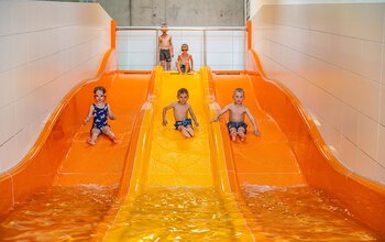 Kinder Rutschen die Trio-Rutsche runter