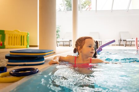 Mädchen schwimmt im Hallenbad