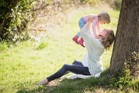 Frau mit Kleinkind unter einem Baum