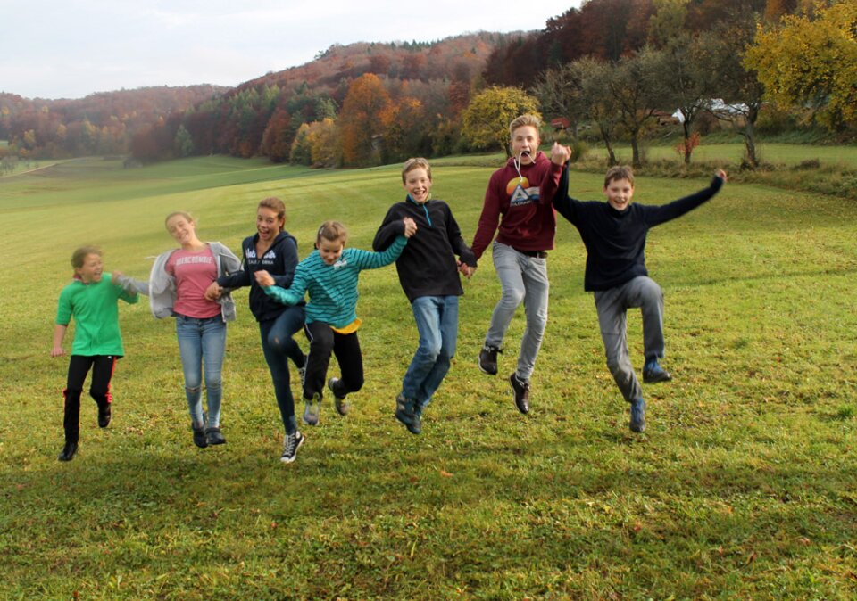 Kinder springen auf der Wiese