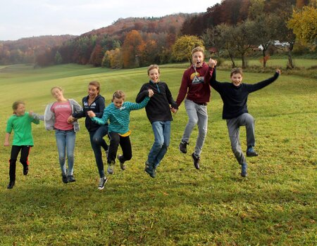 Kinder springen auf der Wiese