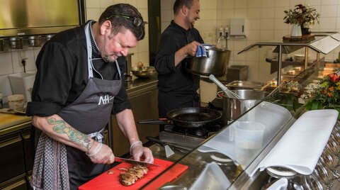 Koch schneidet Fleisch auf