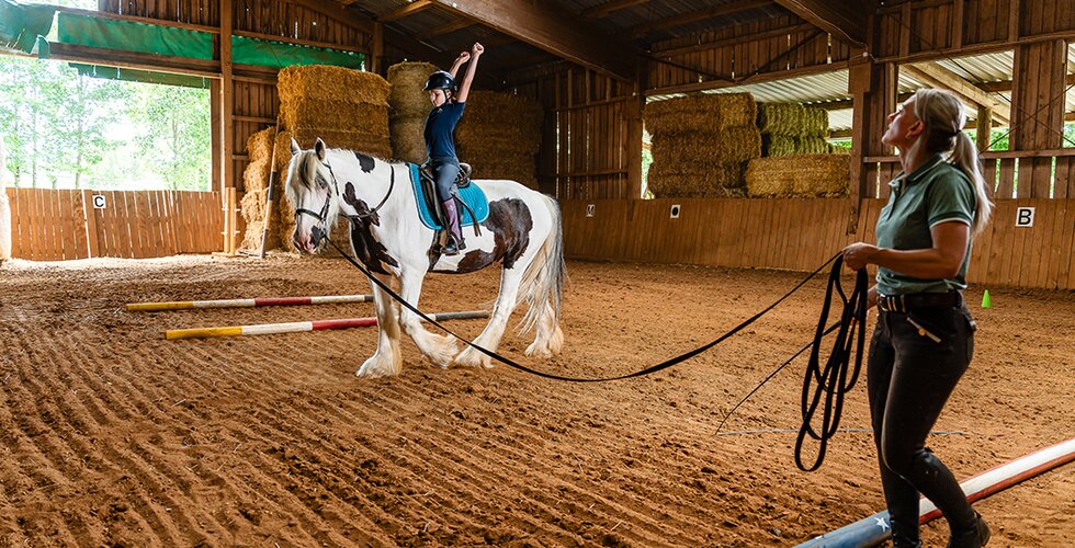 Mädchen beim Reiten in der Reithalle Mädchen beim Reiten in der Reithalle