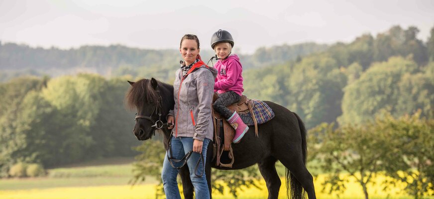 Mädchen beim Ausritt mit Reitlehrerin