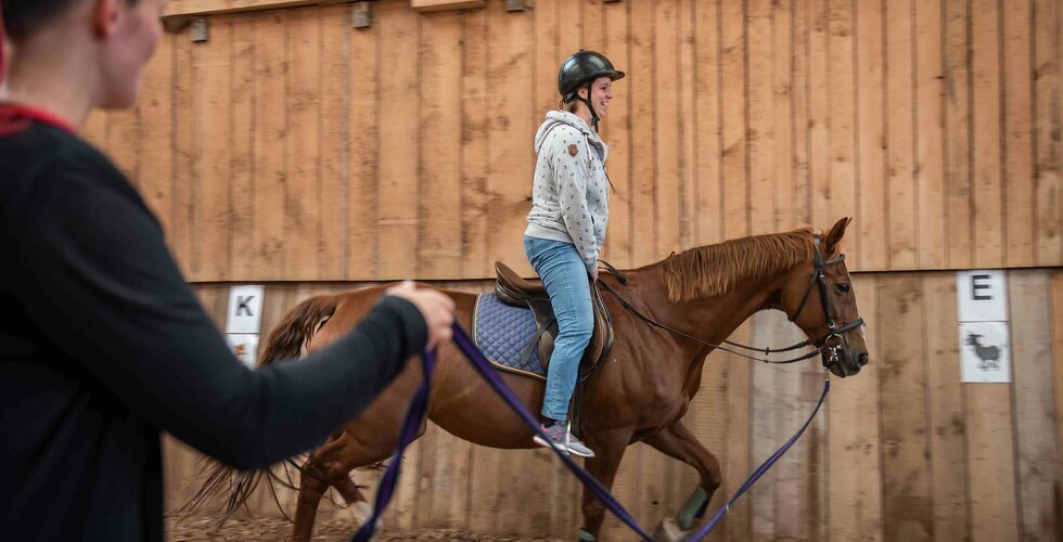 Mädchen beim Reiten in der Reithalle