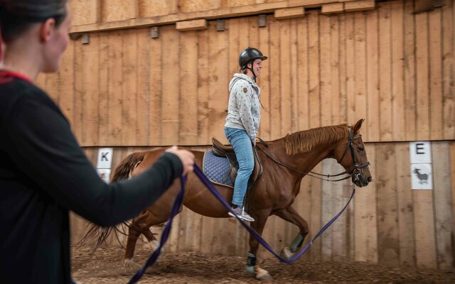 Mädchen beim Reiten in der Reithalle