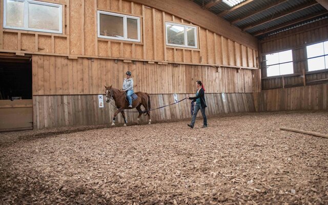 Mädchen beim Reiten in der Reithalle