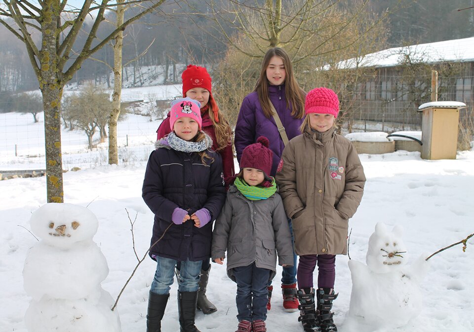 Kindergruppe in Winterlandschaft mit Schneemänner Kindergruppe in Winterlandschaft mit Schneemänner